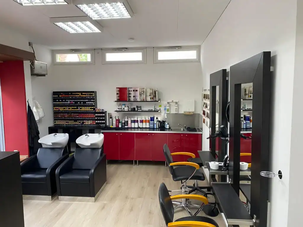 A salon with chairs and mirrors in it.
